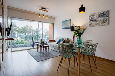 a living room with a table and a couch at BSR Romantic Escape Flat w/ Rooftop Pool in Lima