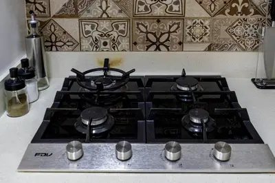a stove top with four burners on it in a kitchen at BSR Romantic Escape Flat w/ Rooftop Pool in Lima