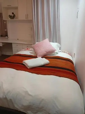 a bed with two white towels on top of it at Si buscas un lugar para tu familia in Cusco