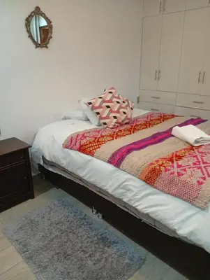 a bedroom with a bed with a rug and a mirror at Si buscas un lugar para tu familia in Cusco