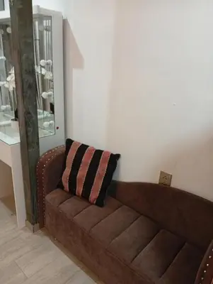 a brown couch in a living room with a pillow at Si buscas un lugar para tu familia in Cusco