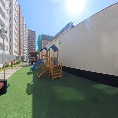 a playground on the side of a building with green grass at Ocean Blue, Vista Frontal Al Mar in Lima