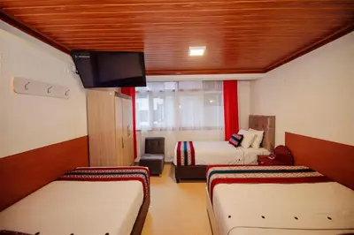 a room with two beds and a flat screen tv at Avraham Hotels in Machu Picchu