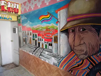 a mural of a man in a hat on a wall at SOLGARDENs in Cusco