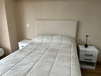 a bedroom with a bed with a white comforter at APARTMENT NEW COMFORTABLE in MIRAFLORES in Lima