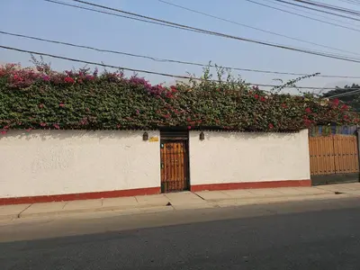 a building with a wooden door with flowers on it at CasaHotel Chaclacayo in Chaclacayo