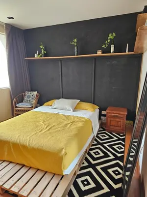 a bedroom with a bed and a black wall at CasaHotel Chaclacayo in Chaclacayo