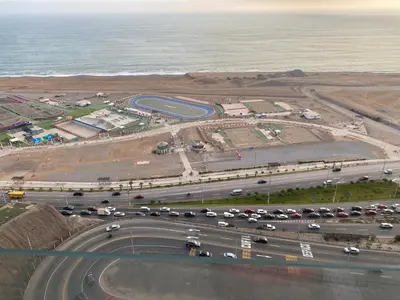 an aerial view of a parking lot next to the ocean at Apartamento familiar 3 habitaciones, piscina cerca a Miraflores in Lima