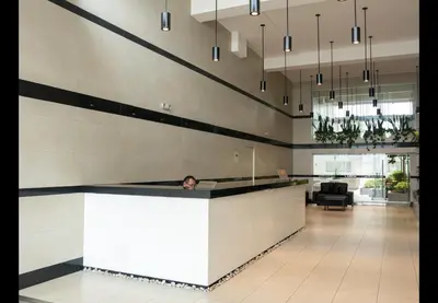 a person sitting at a counter in a lobby at Apartamento familiar 3 habitaciones, piscina cerca a Miraflores in Lima