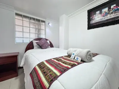 a bedroom with a bed with a blanket on it at Libertrek in Cusco