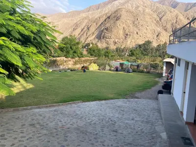 a yard with tents and mountains in the background at Viña J Felix in Lunahuaná