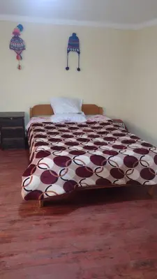 a bed with a brown and white comforter in a bedroom at Roman House 701 in Cusco