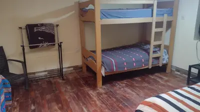 two bunk beds in a room with a wooden floor at Roman House 701 in Cusco