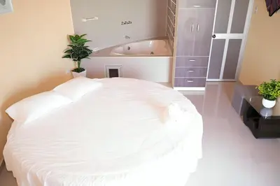 a bedroom with a large white bed and a bath tub at La Casa Redonda - Supe in Barranca