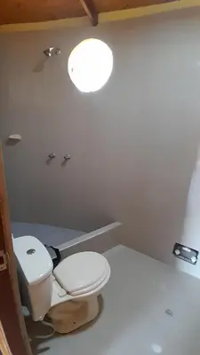 a bathroom with a toilet and a light at La Casa Redonda - Supe in Barranca