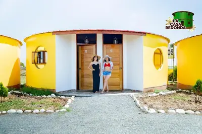 two women standing in the doorway of a yellow and white house at La Casa Redonda - Supe in Barranca