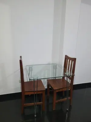 a glass table and two chairs and a table at Departamento cerca del aeropuerto in Lima