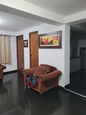 a living room with a couch and a painting on the wall at Departamento cerca del aeropuerto in Lima