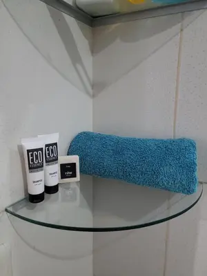 a glass shelf with a blue sponge on a wall at Departamento cerca del aeropuerto in Lima