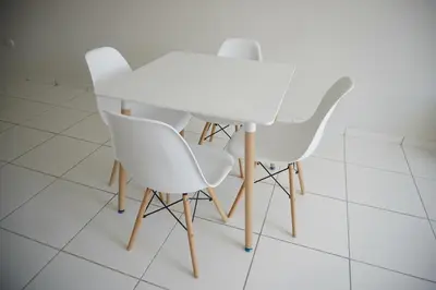 two white chairs and a white table in a room at Jatun Coya in Huancayo