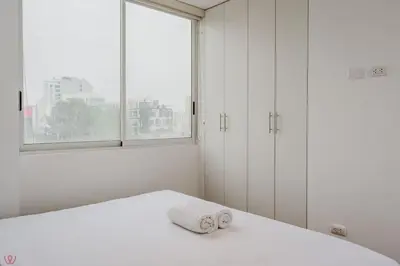 a white room with a bed with two towels at Charming 3BR in Barranco in Lima