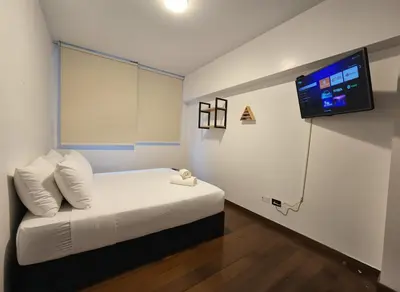 a bedroom with a bed with a tv on the wall at E LarcomarZone Sea View All Inclusive 3B 701 in Lima