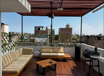 a living room with a couch and a table on a balcony at House in Barranco, Hot Tub & Rooftop Cinema, 11 P in Lima
