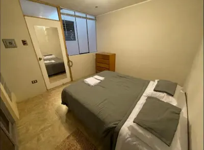 a small bedroom with a bed and a mirror at House in Barranco, Hot Tub & Rooftop Cinema, 11 P in Lima