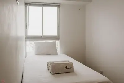 a small bed in a room with a window at Polished 2BR with Balcony in San Isidro in Lima