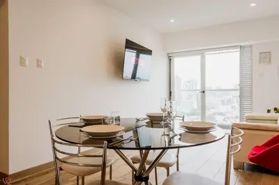 a dining room with a glass table and chairs at Polished 2BR with Balcony in San Isidro in Lima