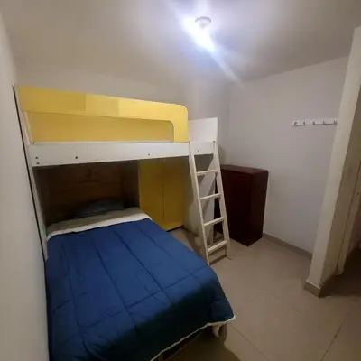 a small bedroom with a bunk bed and a ladder at Departamento 3 cuartos frente al mar en San Miguel, Peru in Lima