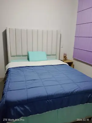 a bed with a blue blanket on top of it at Departamento 3 cuartos frente al mar en San Miguel, Peru in Lima