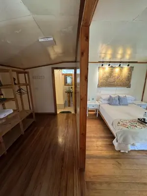 a bedroom with a large bed and a wooden floor at Cabaña con linda vista en Oxapampa in Oxapampa