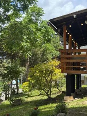 a wooden pavilion in a park with trees and grass at Cabaña con linda vista en Oxapampa in Oxapampa