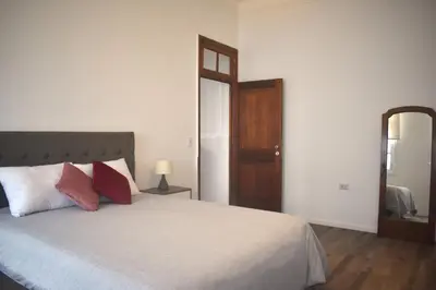 a bedroom with a bed with two pillows and a mirror at MirandoelMar - Luna in Lima