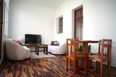 a living room with two chairs and a tv at MirandoelMar - Luna in Lima