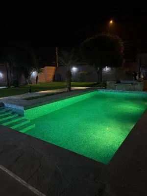 a swimming pool with green lighting at night at Casa los Cipreses del Sol in Cieneguilla