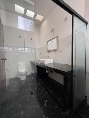 a bathroom with a sink and a glass shower at Casa los Cipreses del Sol in Cieneguilla