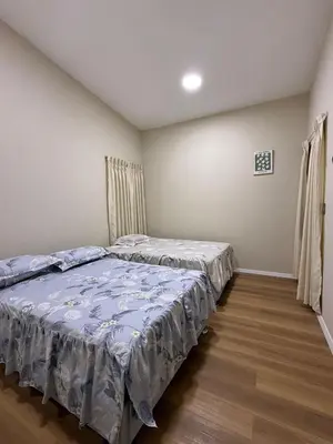 a bedroom with two beds and a wooden floor at Casa los Cipreses del Sol in Cieneguilla