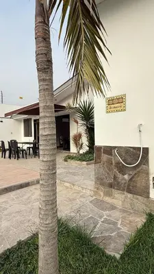 a palm tree in front of a building at Casa los Cipreses del Sol in Cieneguilla