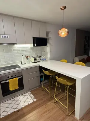 a kitchen with a white counter and yellow chairs at Miraflores La Mar in Lima