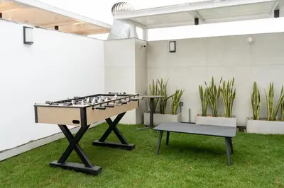 a ping pong table in a yard with grass at Miraflores La Mar in Lima