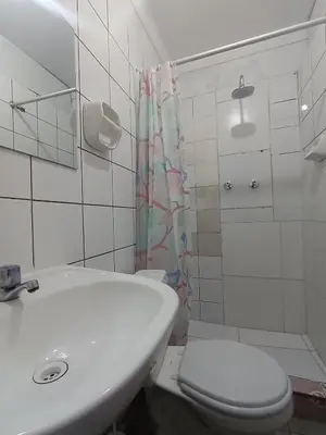 a white bathroom with a toilet and a sink at Ccapaq Wasi II in Cusco