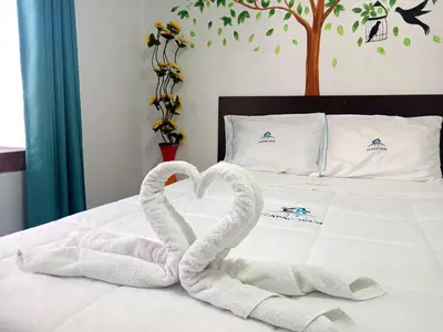 two swans made out of towels on a bed at Ccapaq Wasi II in Cusco