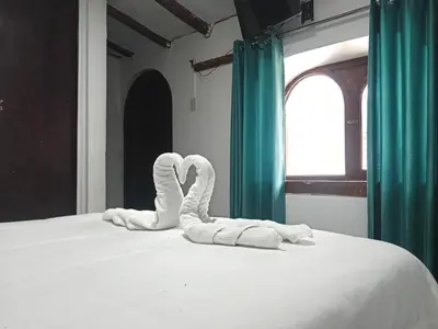 two towels shaped like swans sitting on a bed at Ccapaq Wasi II in Cusco