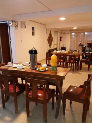 a dining room with a wooden table with chairs at Catari's House in Machu Picchu