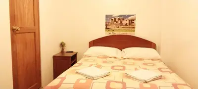 a bedroom with a bed with two books on it at Catari's House in Machu Picchu