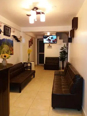 a living room with couches and a flat screen tv at Catari's House in Machu Picchu