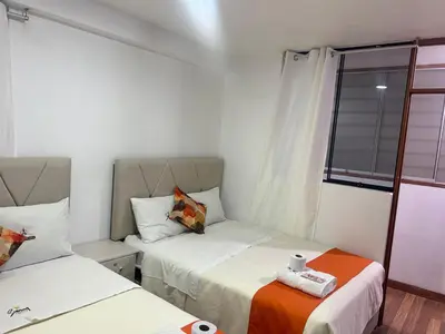 a small room with two beds and a window at Departamentos Sumaq Plaza II in Ayacucho