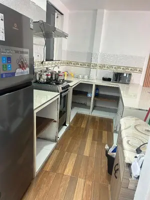 a kitchen with stainless steel appliances and wooden floors at Departamentos Sumaq Plaza II in Ayacucho